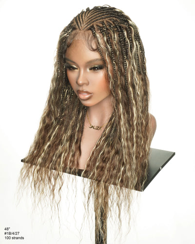 JALIZA Avery Fulani braided wig in blend blond #1B/4/27 shown on a mannequin bust — two-step cornrow top with pre-bleached full lace frontal, side box braids and boho wavy human hair curls falling past the shoulders, styled with a gold JALIZA necklace.